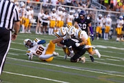 Pioneer’s Sory Yansane (4) is tackled by Saline's Allen Saidov (90), Tyler Parrish (40) and Brady Clark (10) during a Division 1 high school football game at Ann Arbor Pioneer High School on Friday, Sept. 13, 2024. Saline won the game over Pioneer, 50-0. (Sydney Verlinde | For MLive.com)