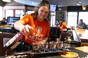 Sarah Kocina, a server at Sundance Grill and Bar, pours beverages at the bar in Grand Rapids, Mich. on Thursday, August 22, 2024.